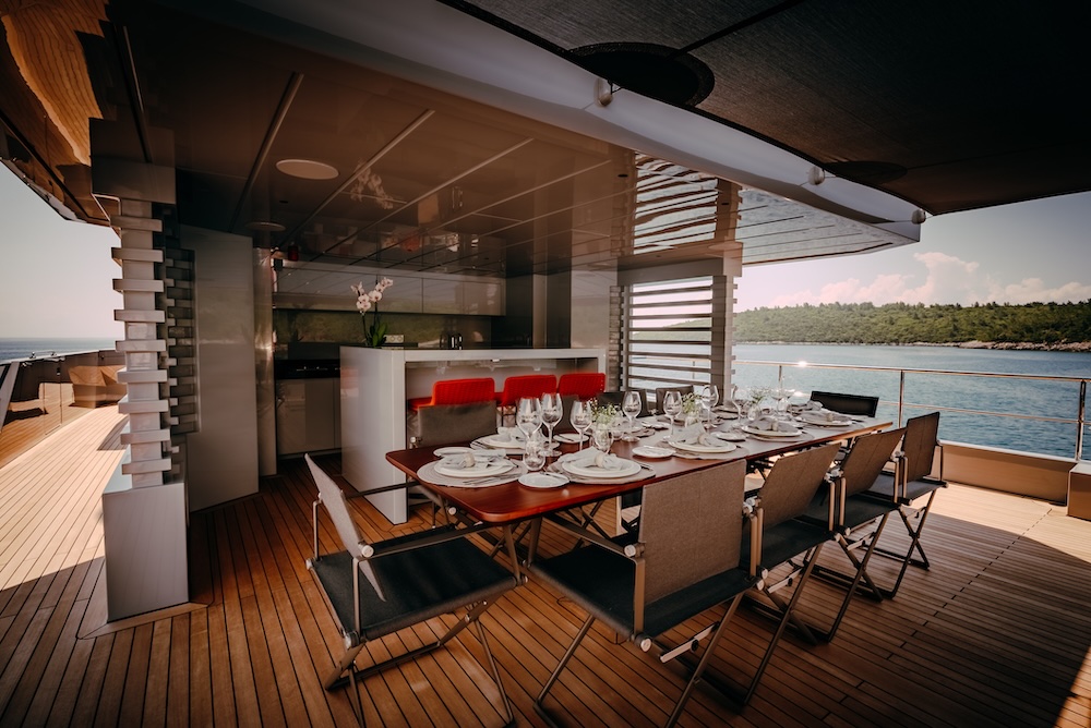 Alfresco dining area on upper deck of CARMEN yacht with open sea views