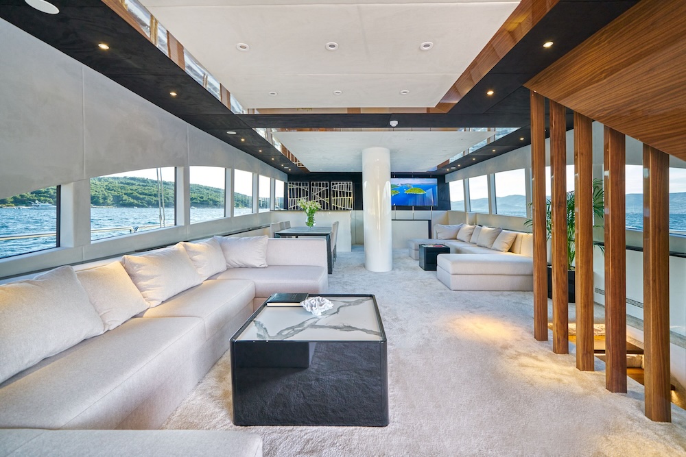 Acapella yacht main salon with panoramic windows and spacious lounge seating