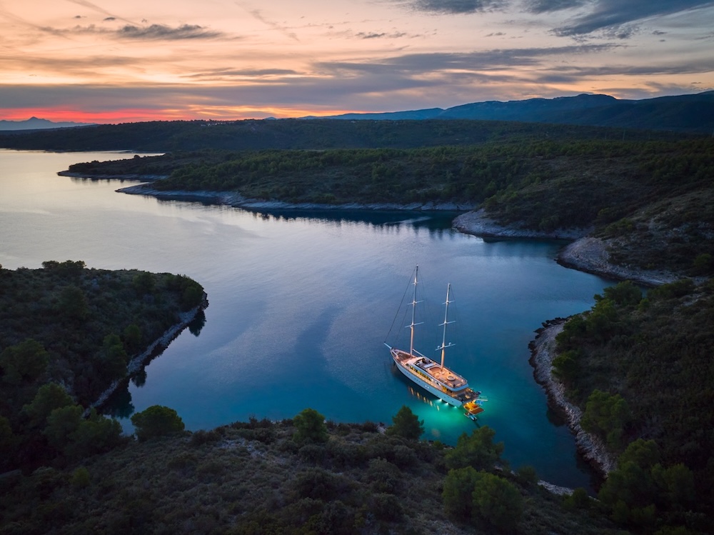 Outdoor dining on Love Story yacht at sunset with warm light and sea views