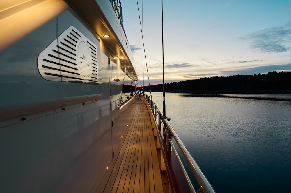 Yacht at anchor in calm sea during golden hour with open horizon