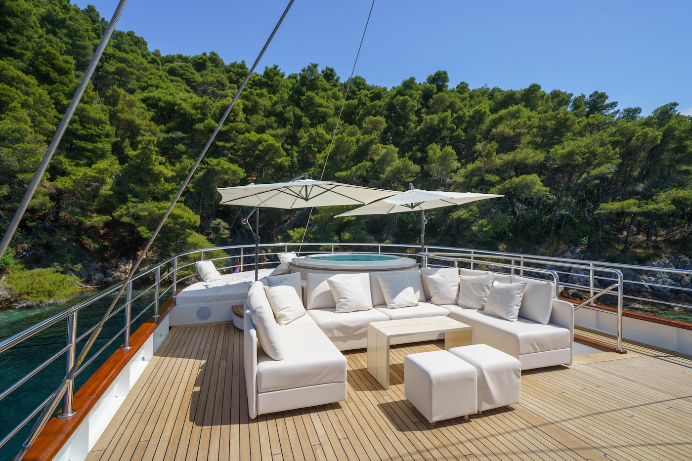 MAIA yacht sundeck with jacuzzi, sun loungers, and shaded seating area