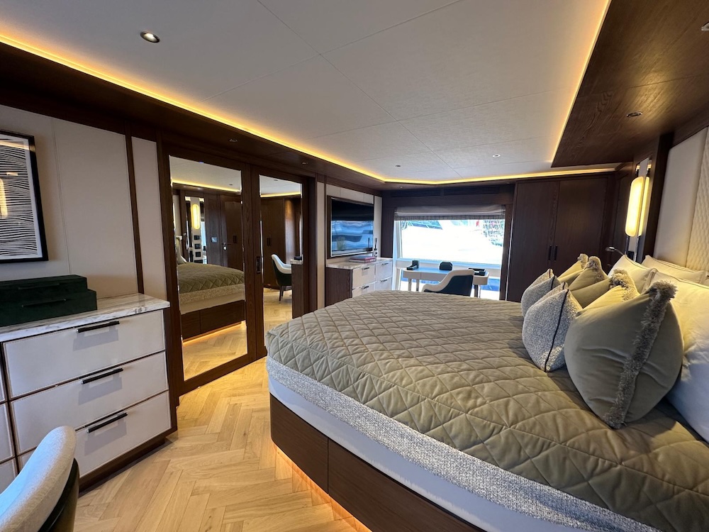Master cabin on Majera yacht with large windows, warm wood finishes, and sea views