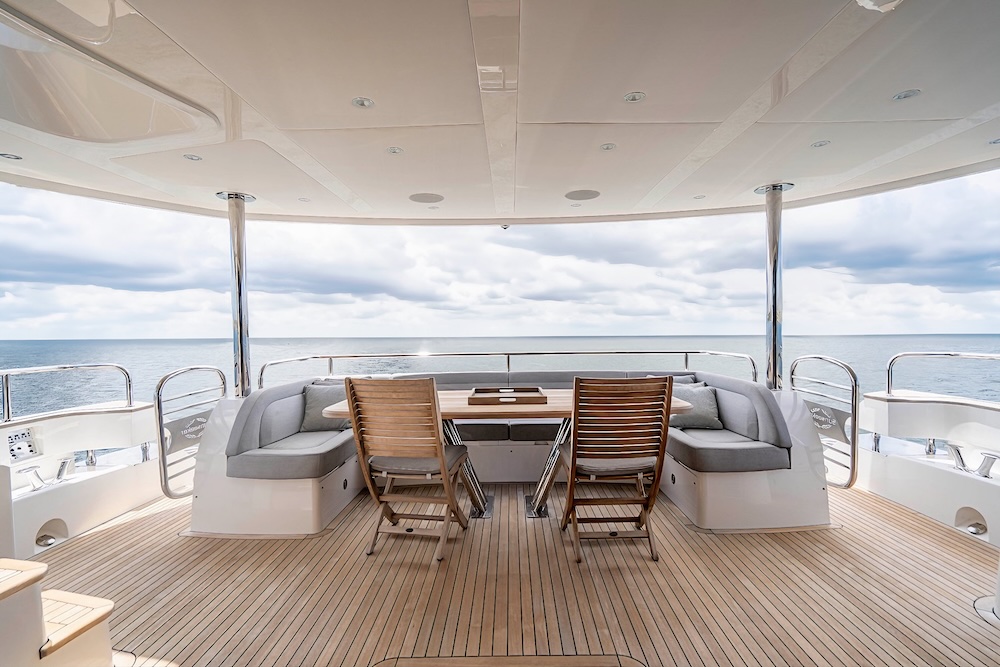 Aft deck dining area on Quantum yacht with open sea views and shaded seating
