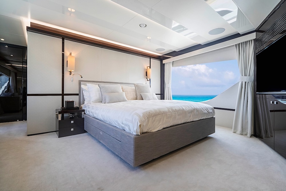 Master suite aboard Quantum yacht with large windows and soft neutral interior overlooking the sea