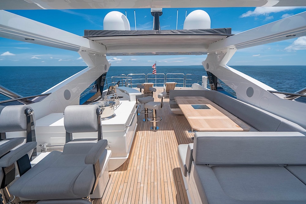 Sun deck on Quantum yacht with lounge seating, bar, and open ocean views