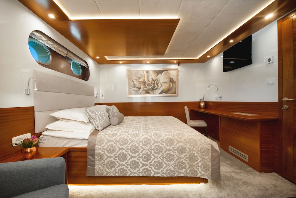 Son de Mar master cabin with warm wood finishes and soft ambient lighting