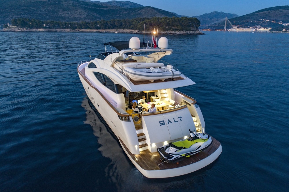 Guests enjoying aft deck living area on yacht SALT at sunset