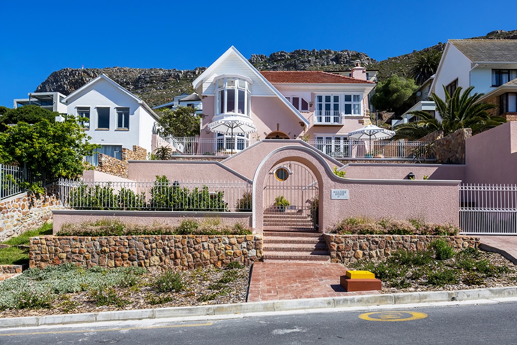 Pink façade entrance of Villa Issima Hillside House overlooking the Atlantic coastline in Cape Town
