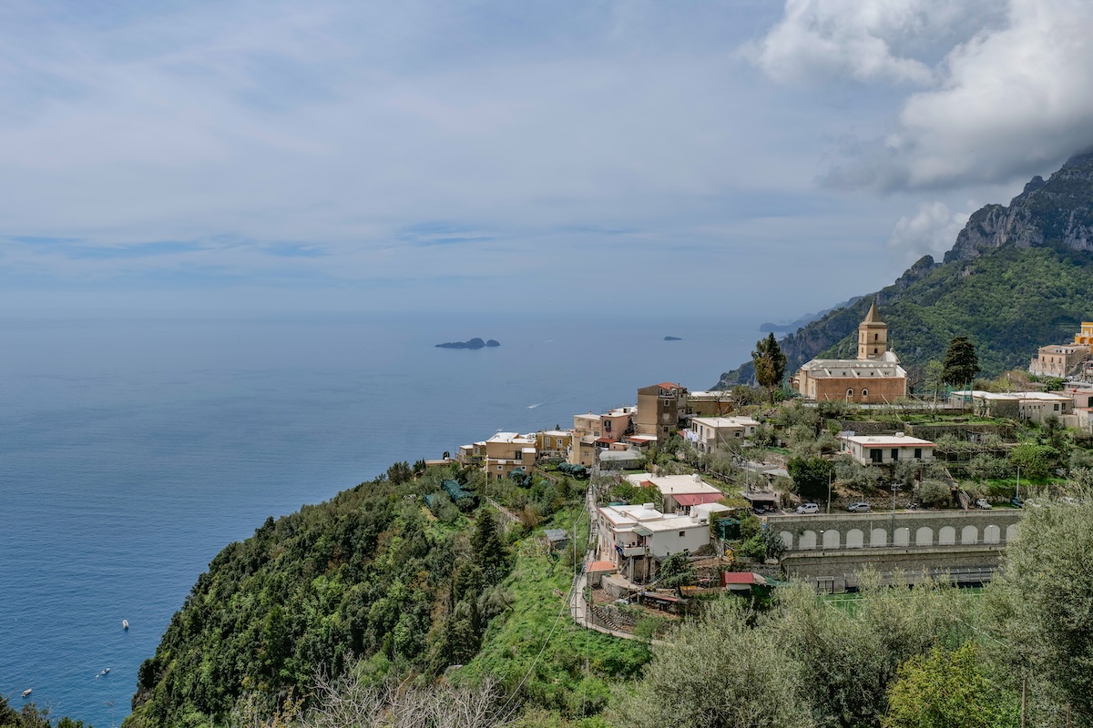 Elevated view of an Amalfi Coast village overlooking the Mediterranean Sea with calm horizon and hillside landscape in Italy