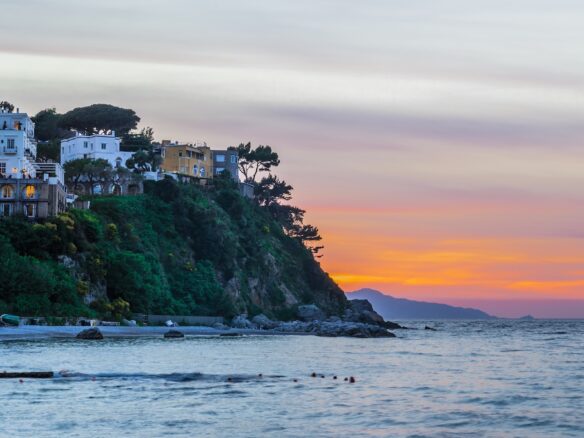 Amalfi Coast coastal village at sunset with calm Mediterranean sea and soft pastel sky in Italy