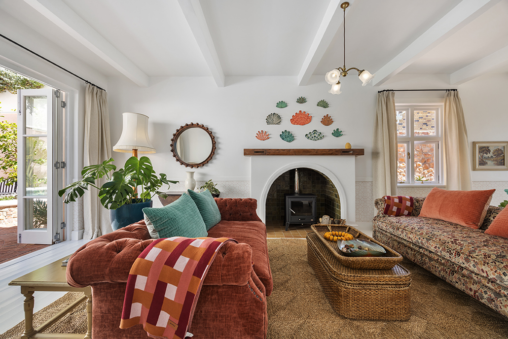 Colorful coastal living room with fireplace and decorative wall art at Villa Issima