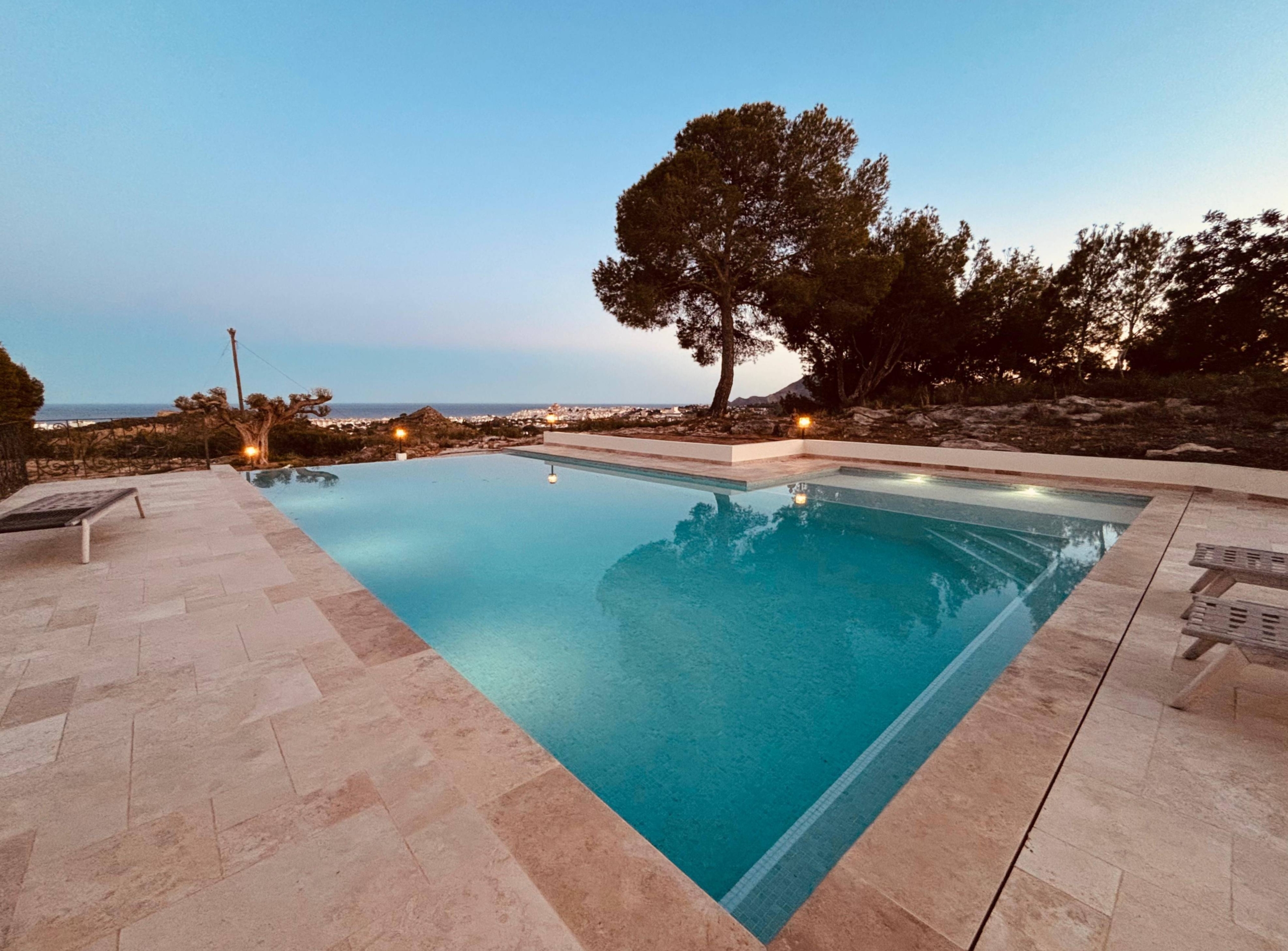 Private villa pool terrace at sunset with open views and surrounding nature