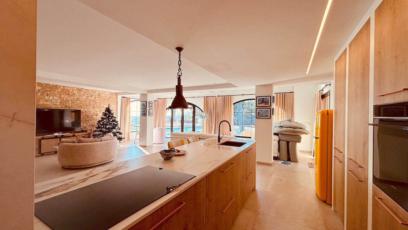 Open-plan kitchen with island connected to spacious living area