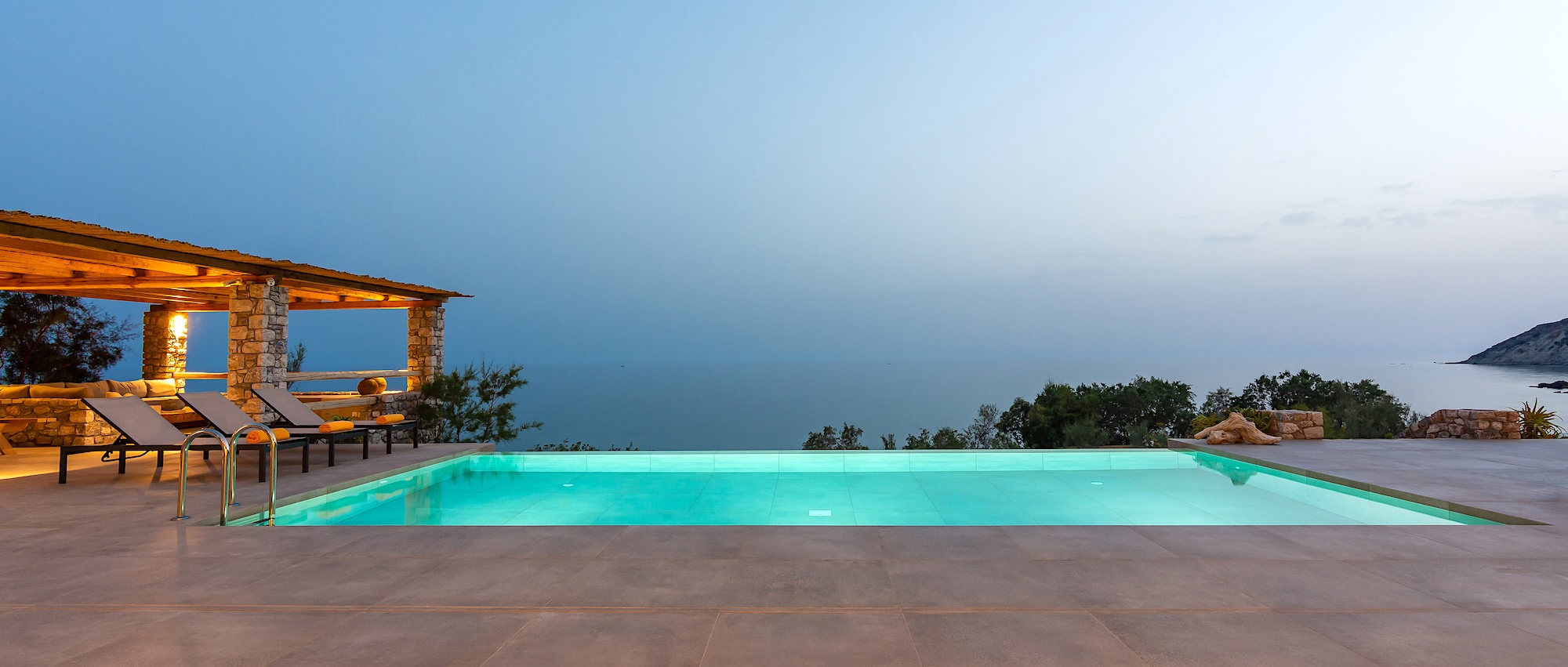 Evening pool terrace overlooking the sea at a beachfront villa in Crete