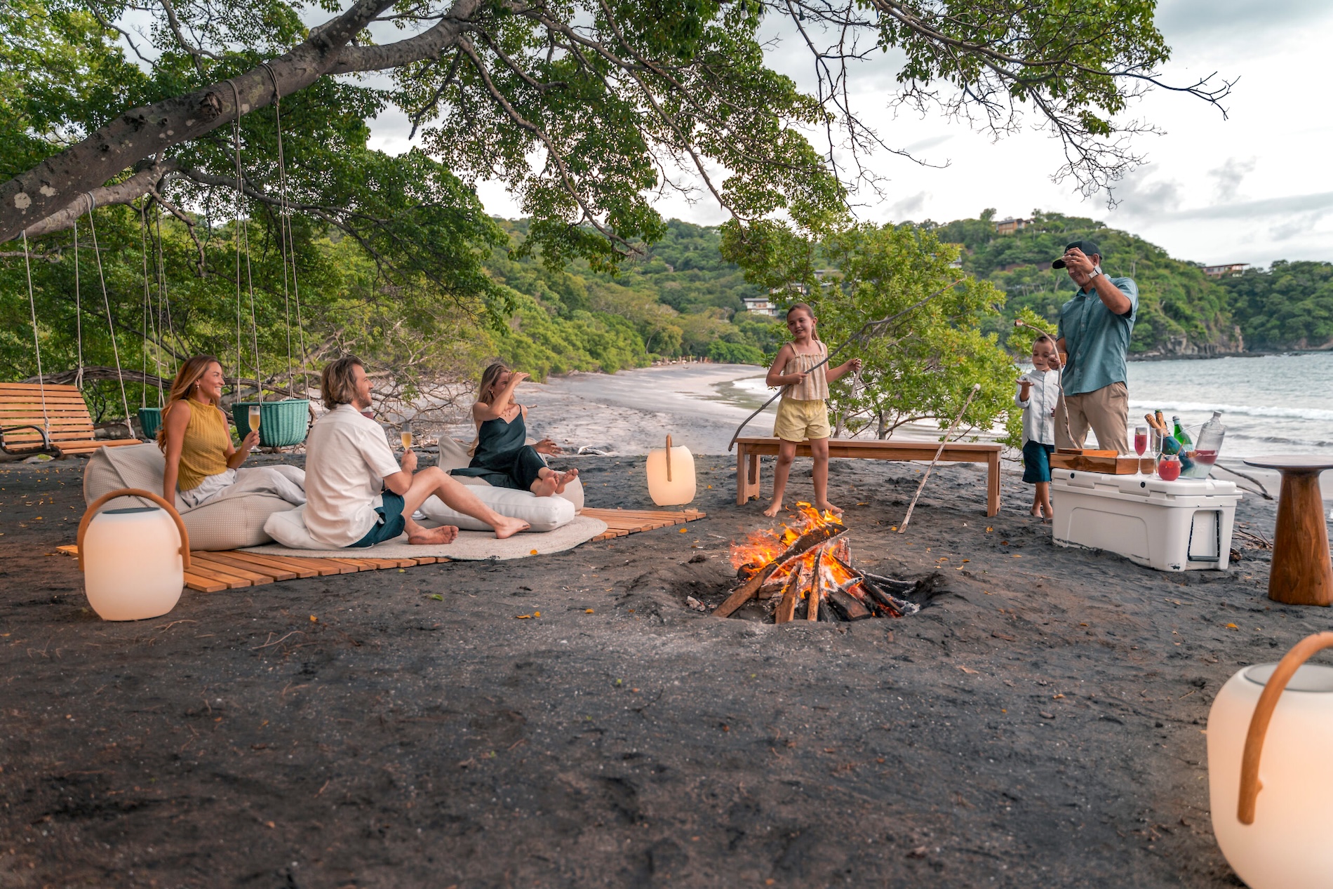 Family gathering around a beach fire near Villa Avellana