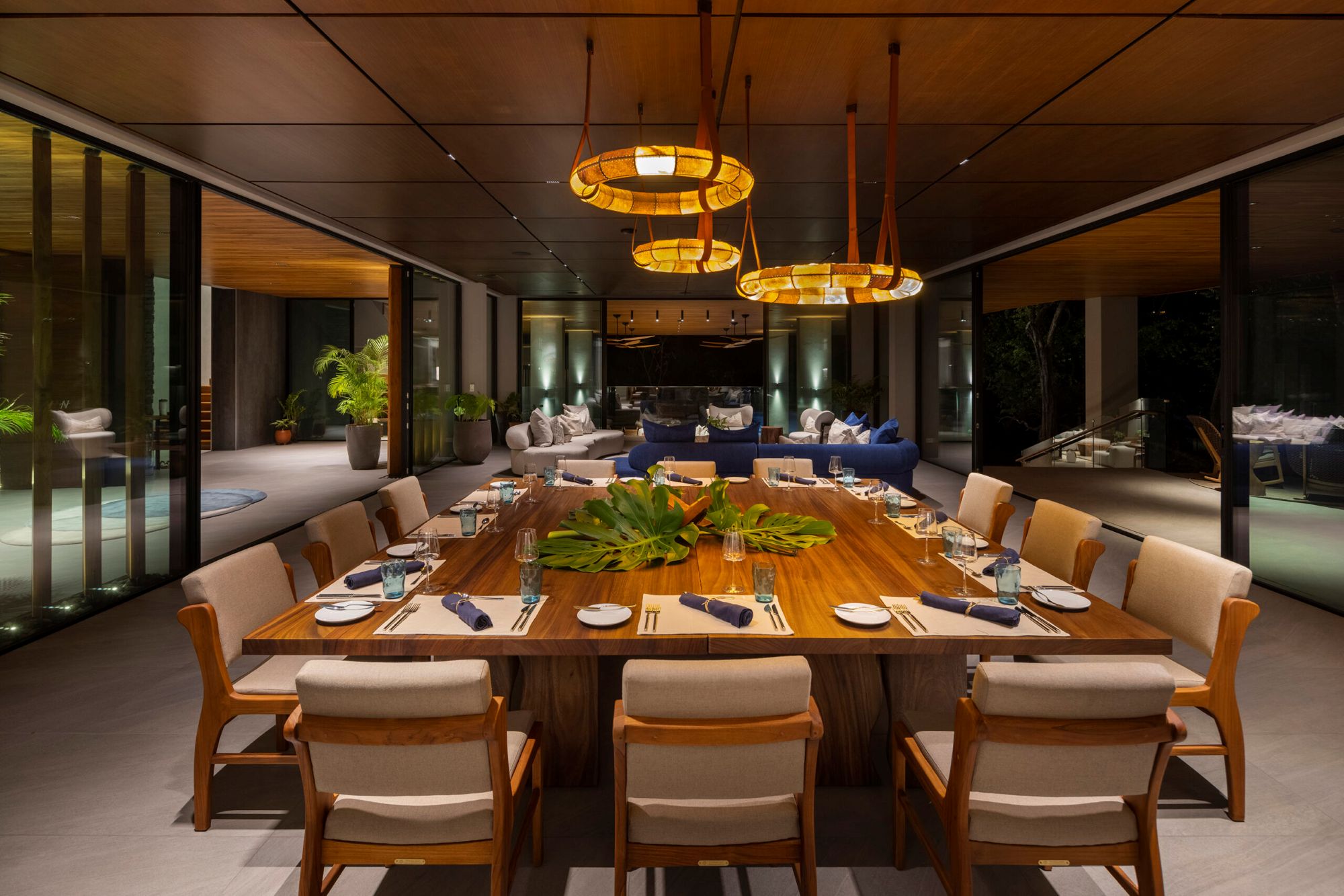 Open-plan coastal dining and living area with natural wood at Villa Avellana