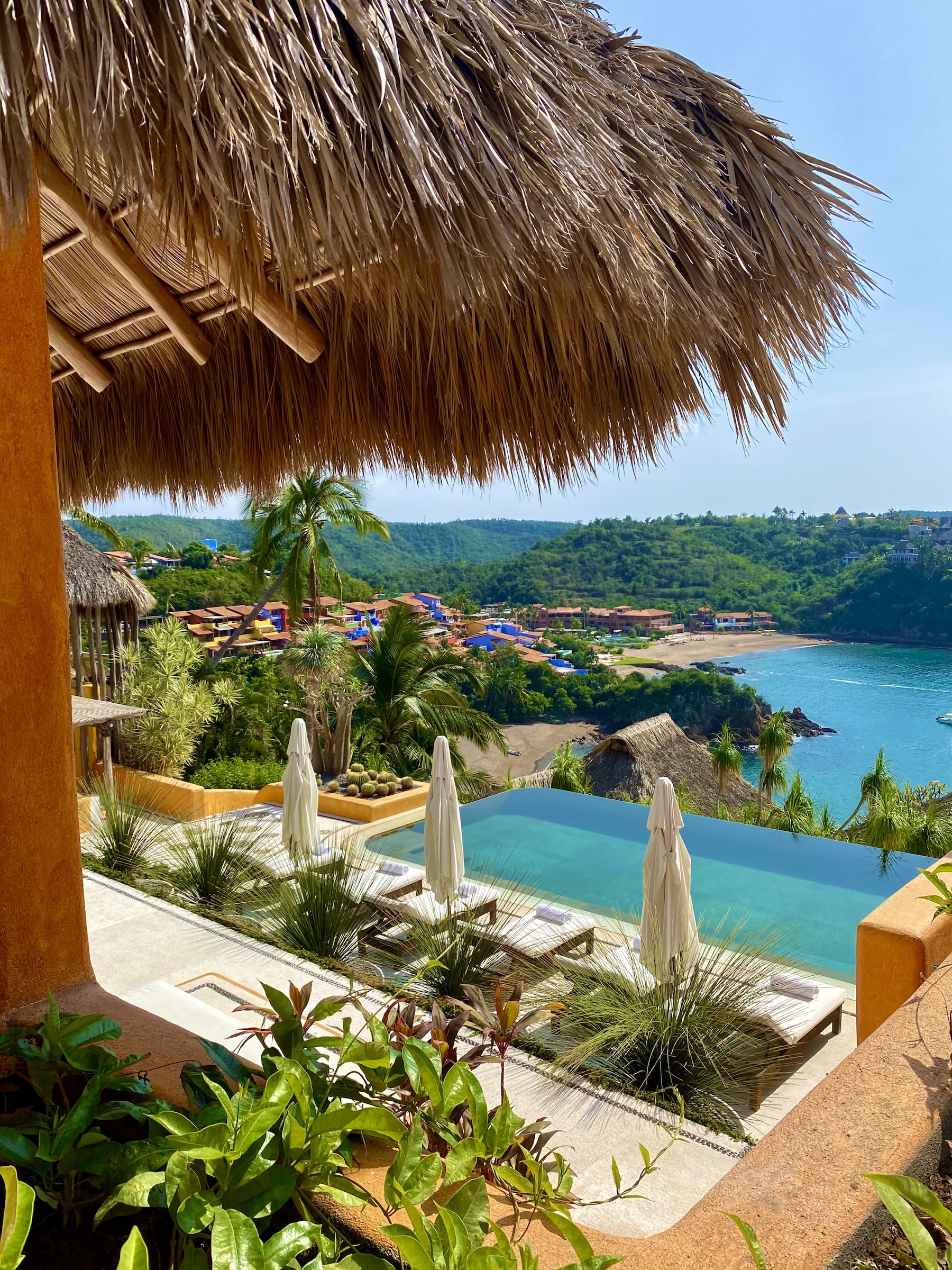 Infinity pool at Casa Torre overlooking the tropical coastline and colourful homes of Careyes, Mexico.
