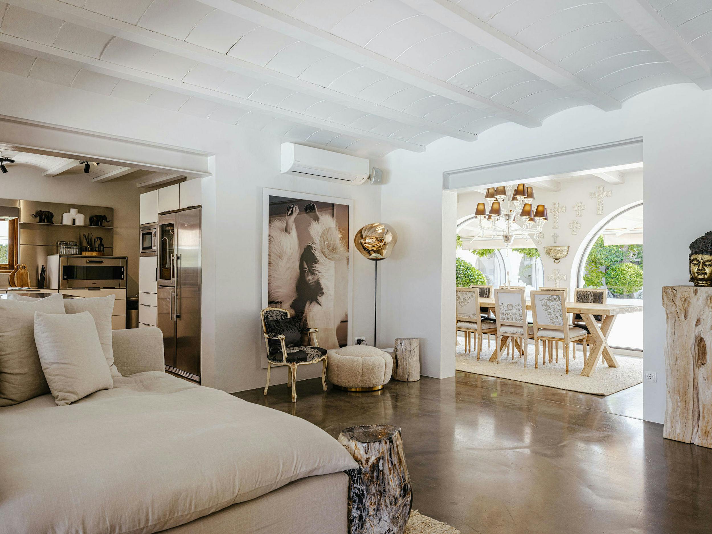 Open-plan interior at El Zafiro in Ibiza, with white sofa seating, a contemporary kitchen, and a dining area overlooking the courtyard.