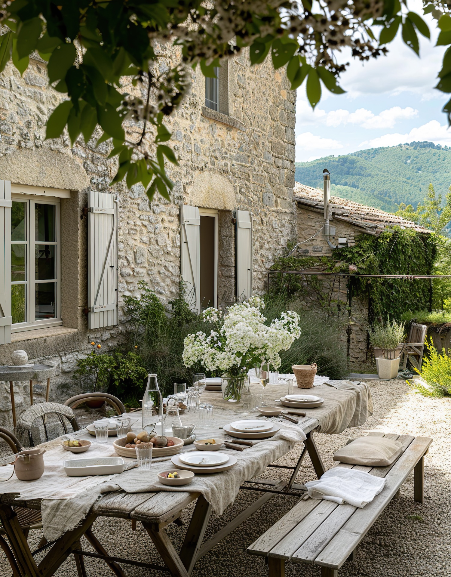 Outdoor dining table beside a traditional stone country house