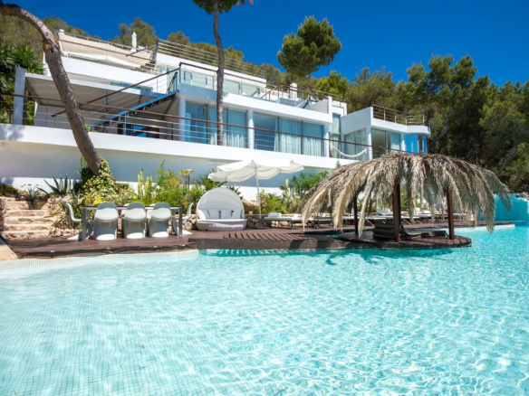 Villa Destiny in Ibiza, with its white contemporary exterior overlooking a large swimming pool and poolside seating
