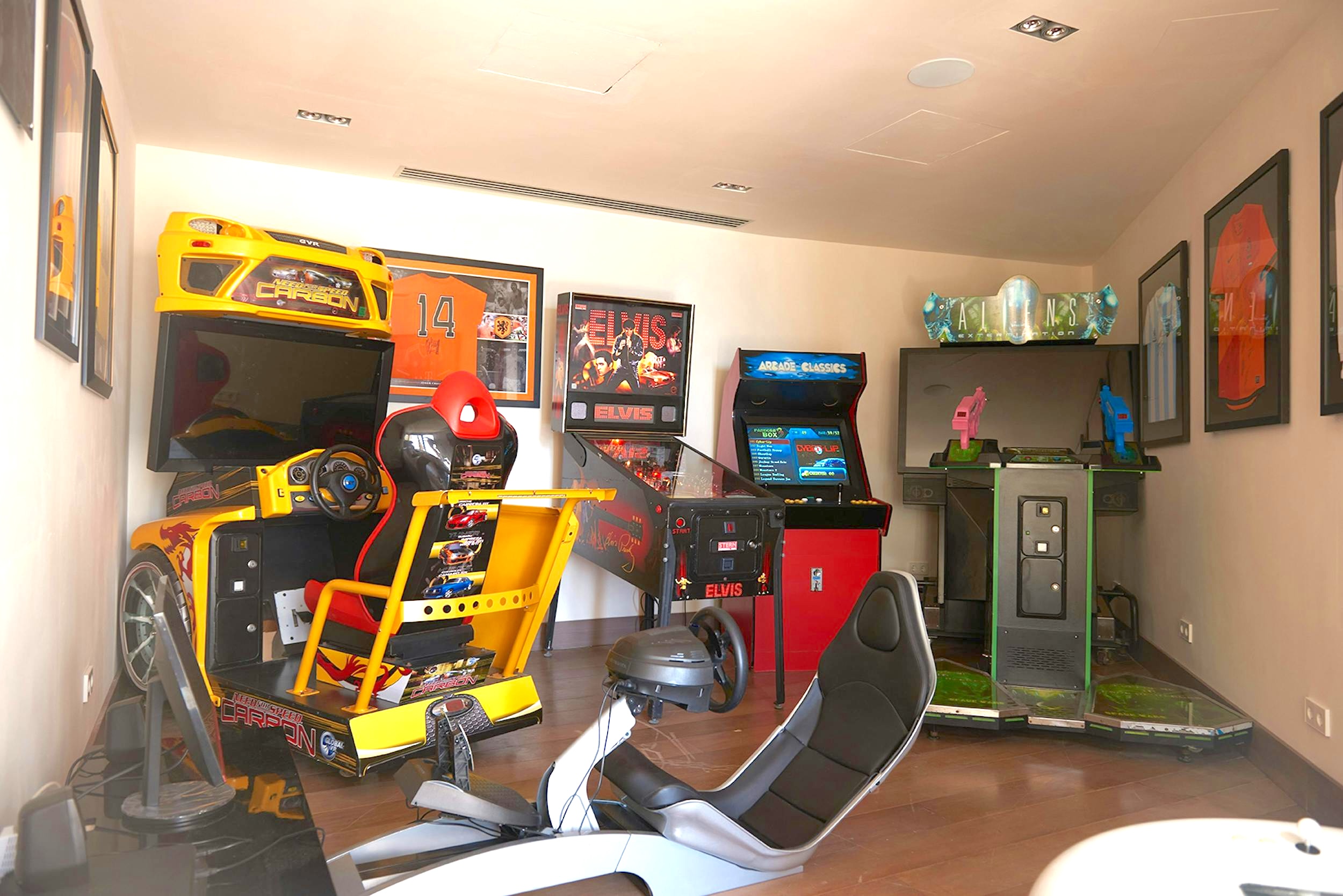 Games room at Ocean Paradise Ibiza with racing arcade machines, pinball, and framed sports memorabilia